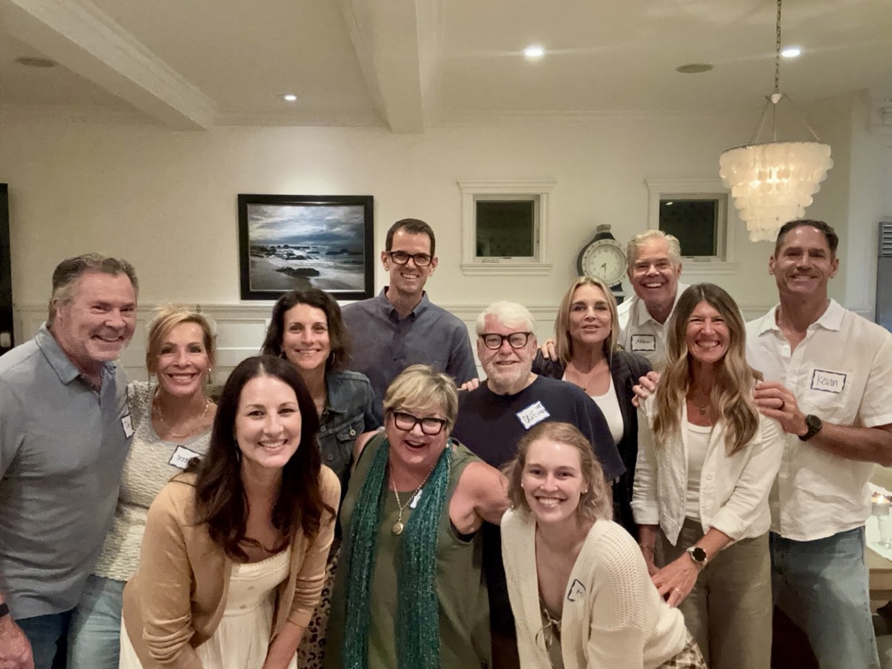 A large group of friends smiling together in Megan’s living room