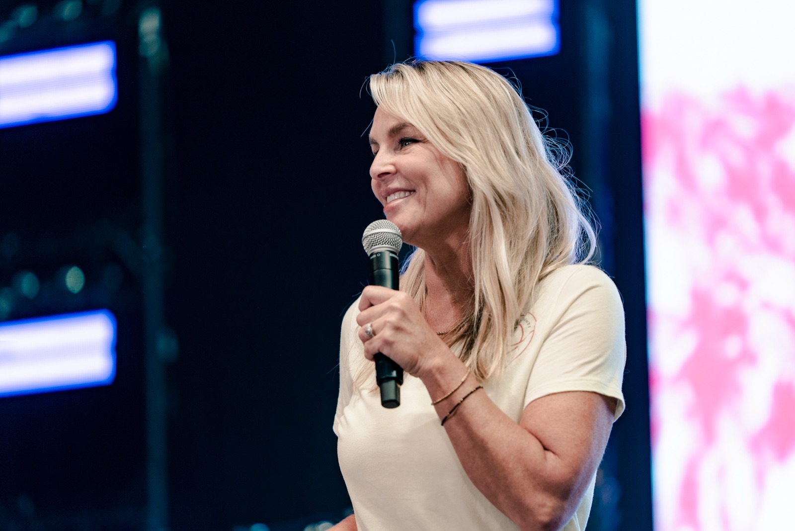 Megan speaking on stage with a microphone